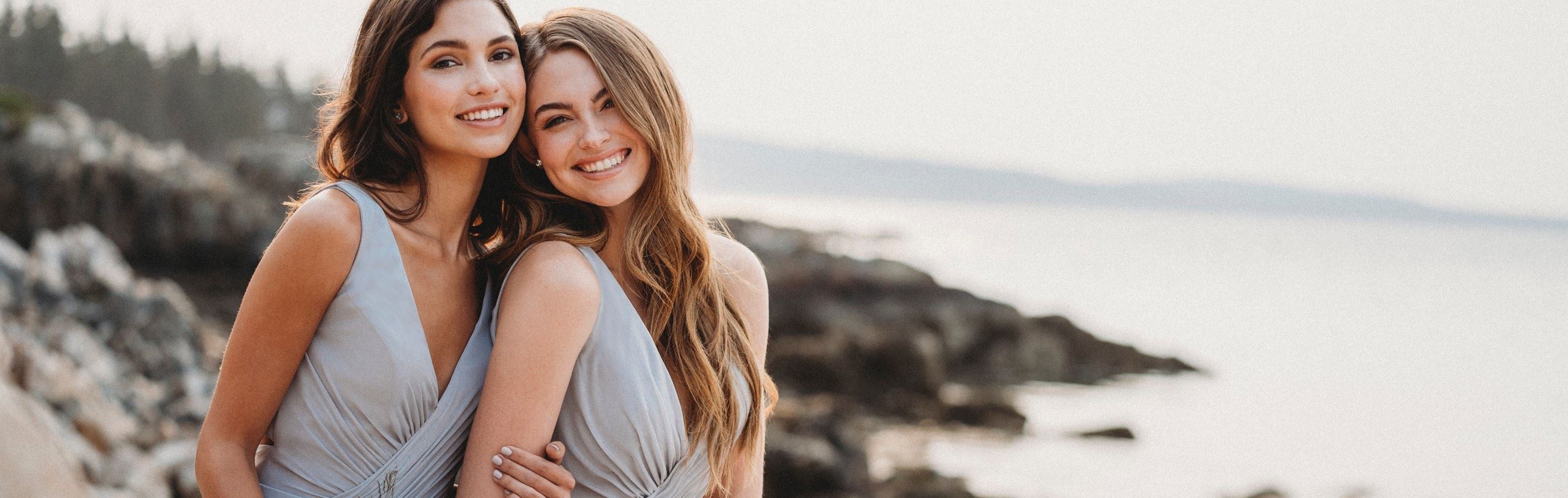 Two girls in bridesmaid dresses hugging