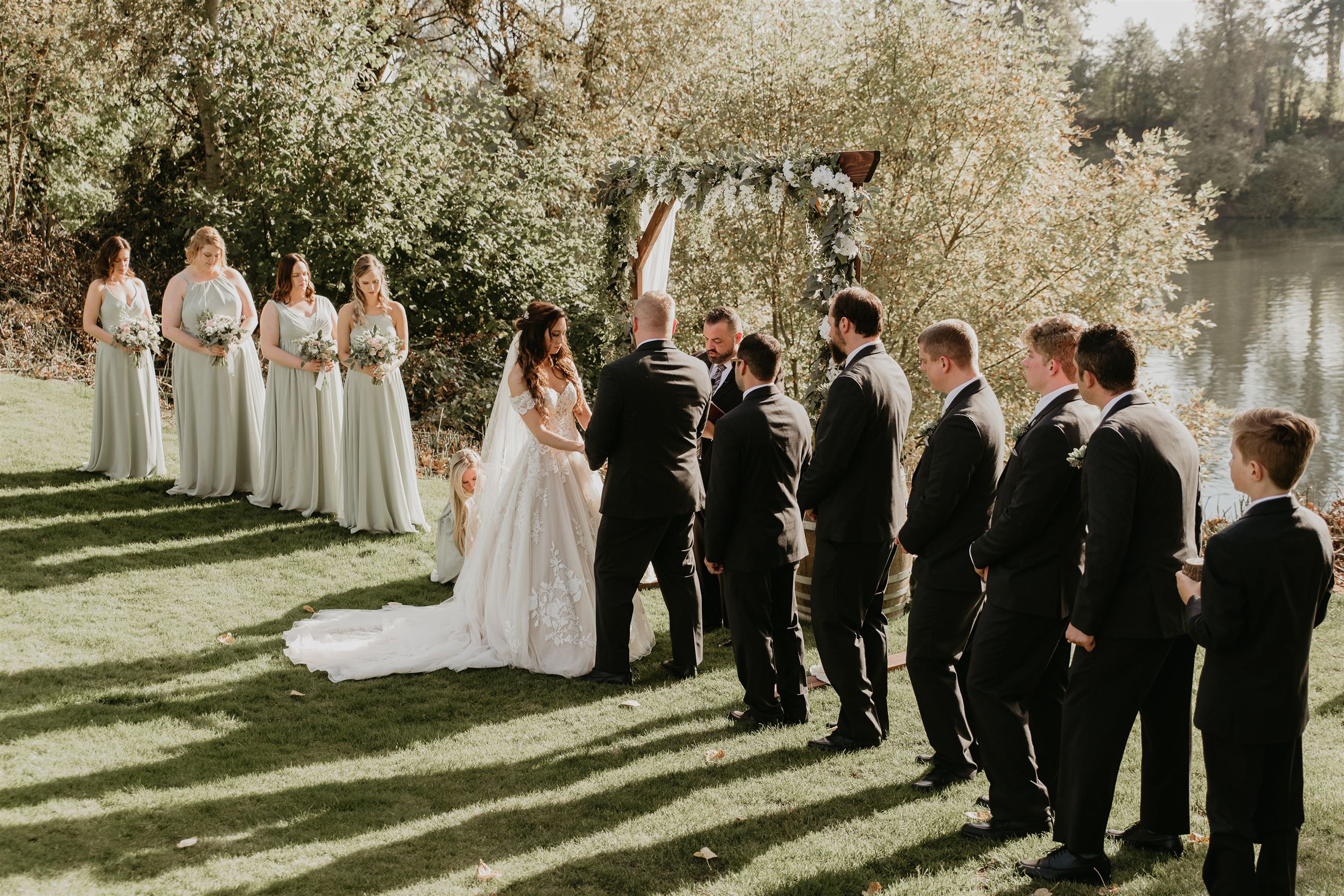 Bride and groom holding hands at the altar with bridal party standing on either side