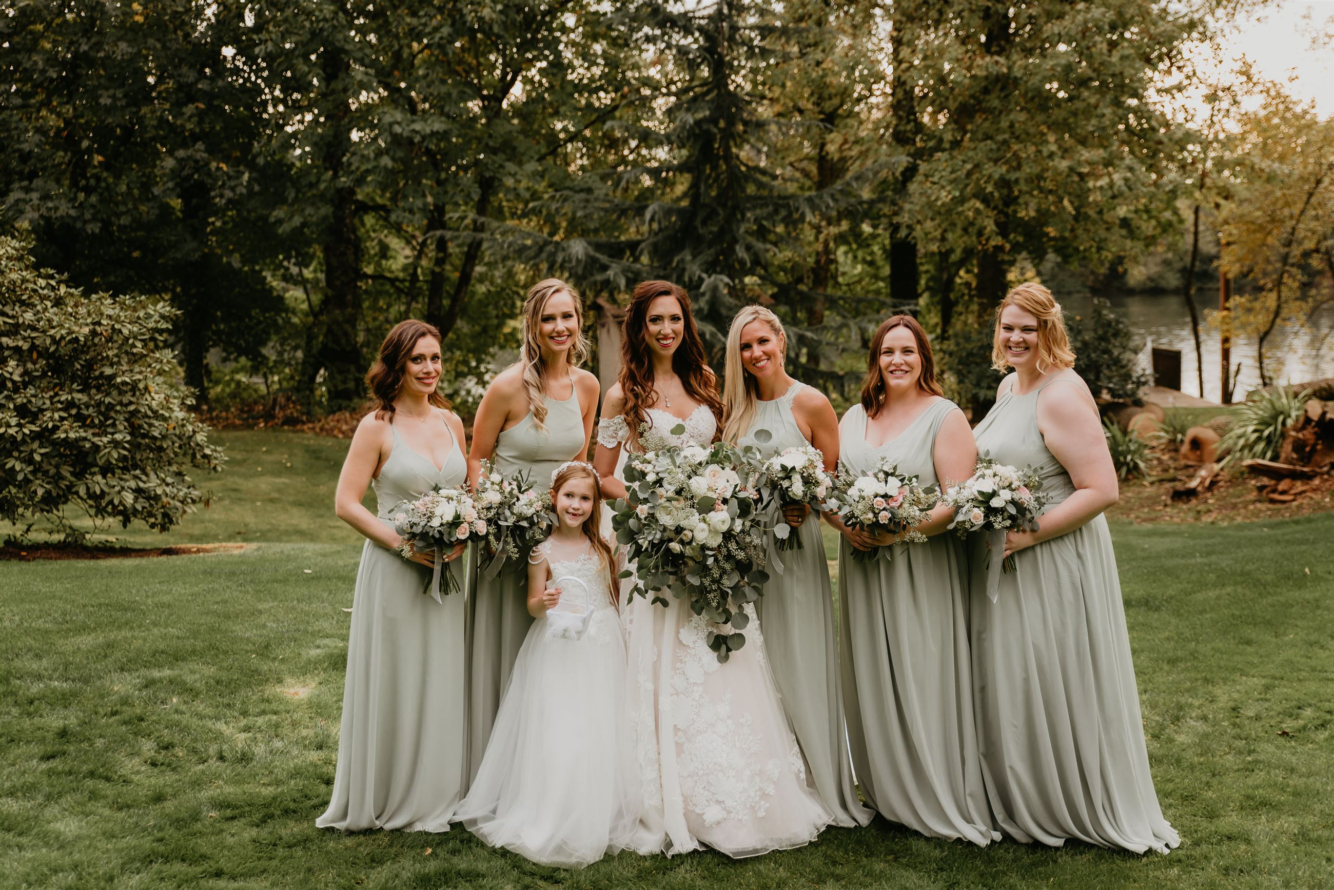 Bridesmaids in sage green bridesmaid dresses posing with bride