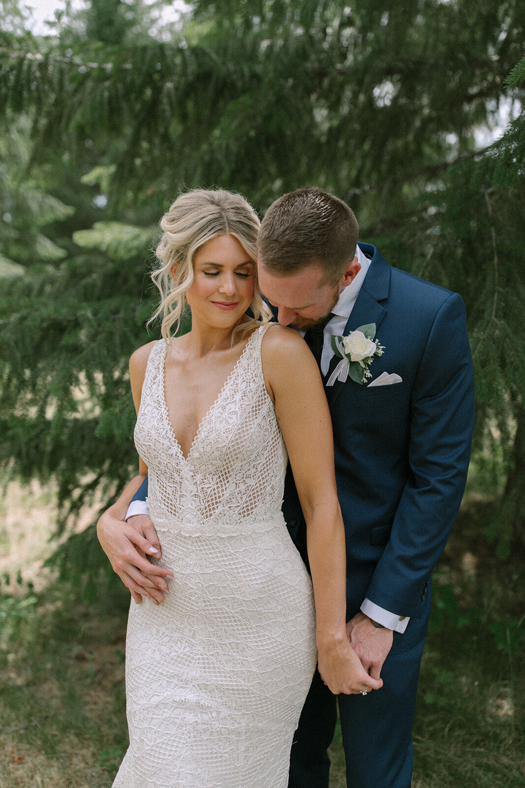 Groom in blue suit and bride in all over lace fit and flare wedding gown from Charlotte's Weddings
