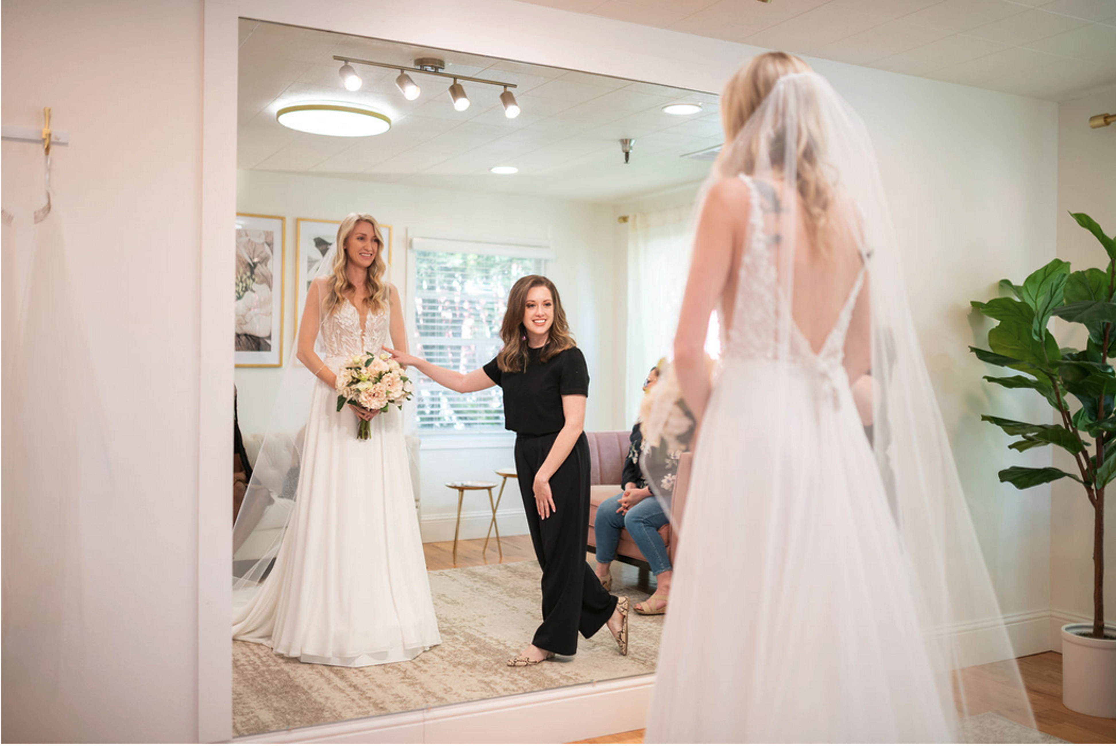 Bride admiring herself in the mirror with her Stylist by her side