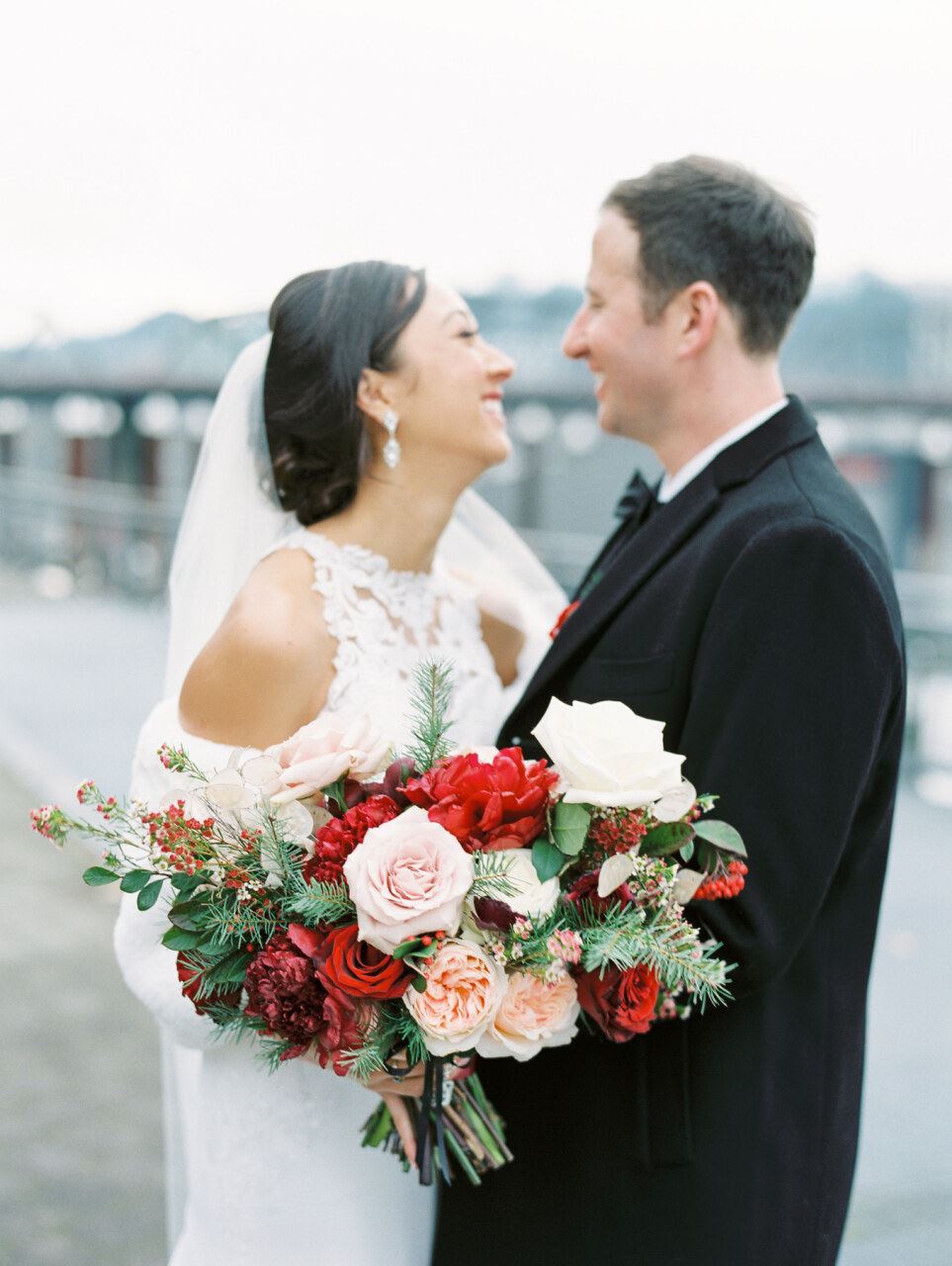 Bride and groom smiling with floral bouquet